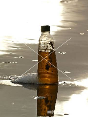 Fles met inhoud op strand bij Noordpier 5