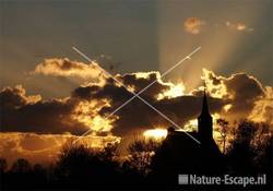 Zon door dreigende wolken bij kerk Krommeniedijk 1